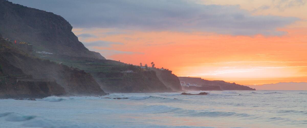 A coastal sunset with cliffs and waves.