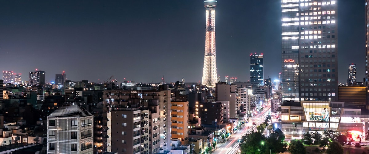 A cityscape at night with the Tokyo Tower and modern buildings.