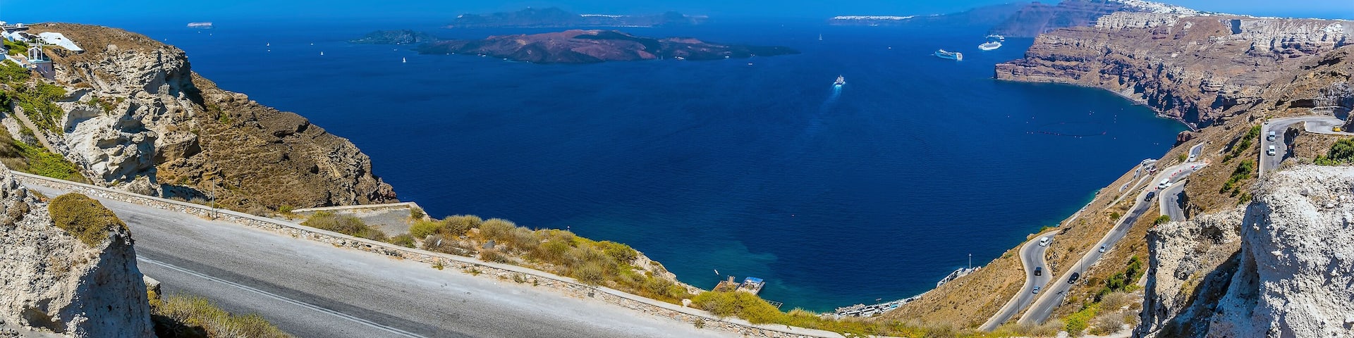 A panorama view down to the harbour at Athinios Port Santorini in summertime