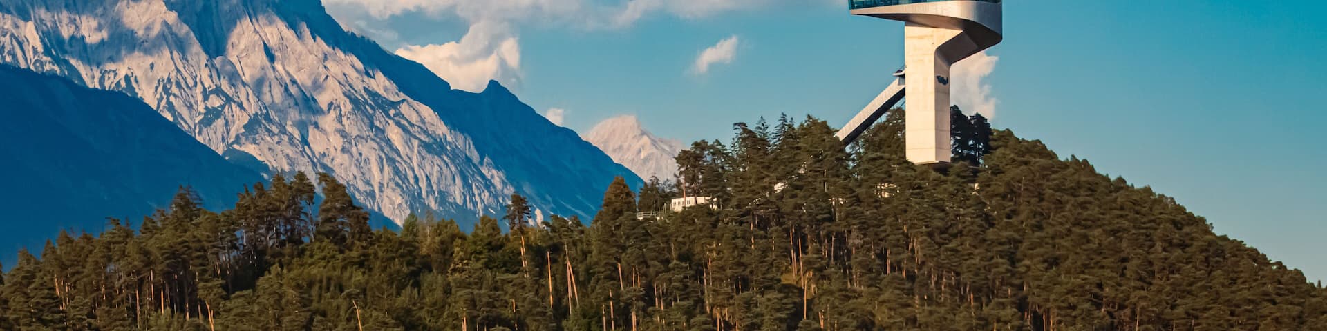 Alpine summer view with the famous Berg Isel Ski Jump Tower and the Nordkette mountains in the background near Innsbruck, Austria