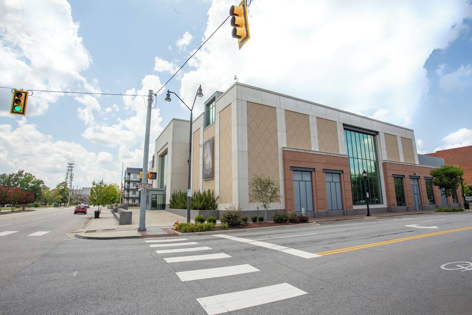 A modern building with large windows and a crosswalk at an intersection.