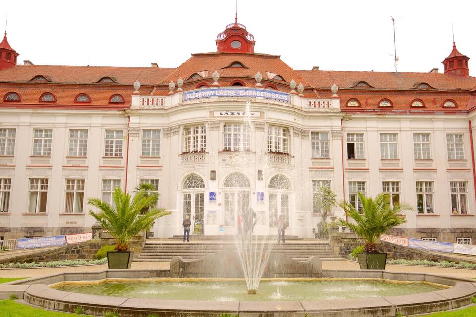 A historic building with a fountain, red-tiled roof, and classical architecture.