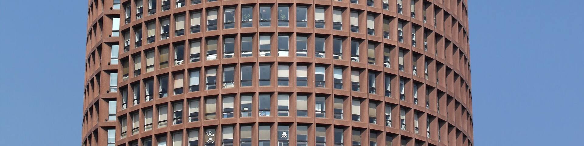 A tall, cylindrical building with a grid-like facade and the text "TOUR PART-DIEN RADISSON BLU" on its side.