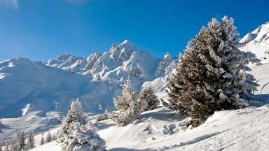 A snow-covered mountain landscape with a clear blue sky.