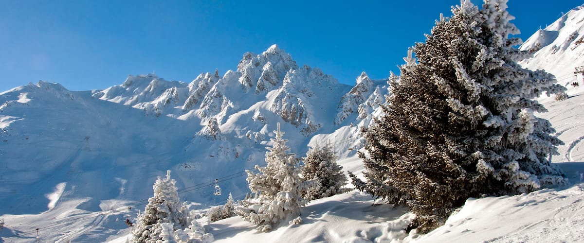 A snow-covered mountain landscape with a clear blue sky.