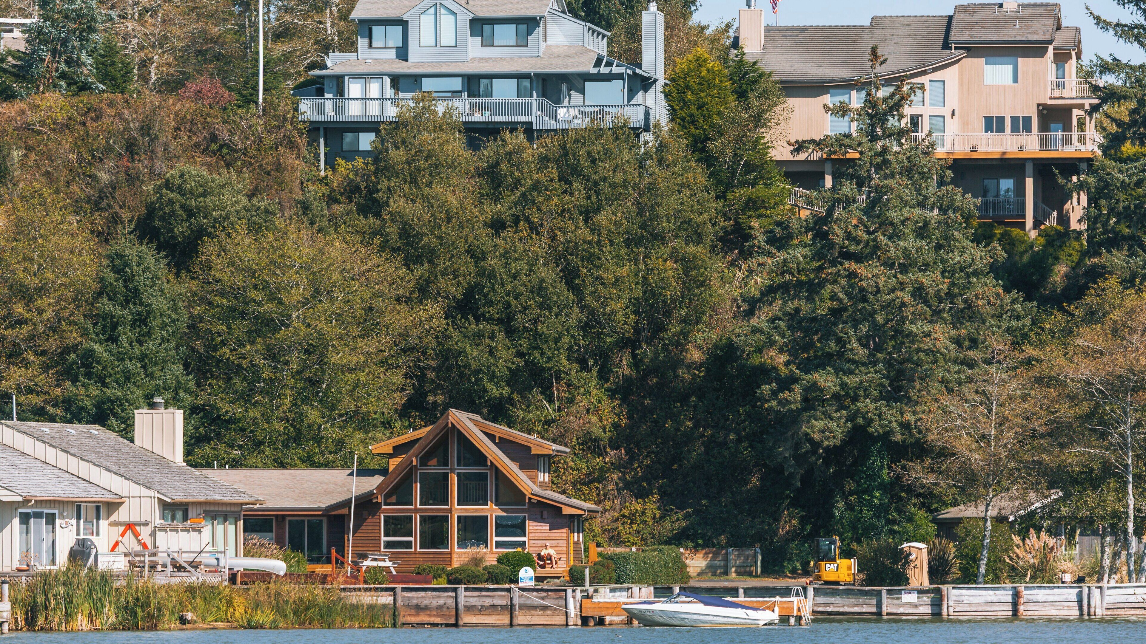 Scenic view of Devil's Lake State Recreation Area in Lincoln City, Oregon showcasing charming homes and lush greenery by the water's edge