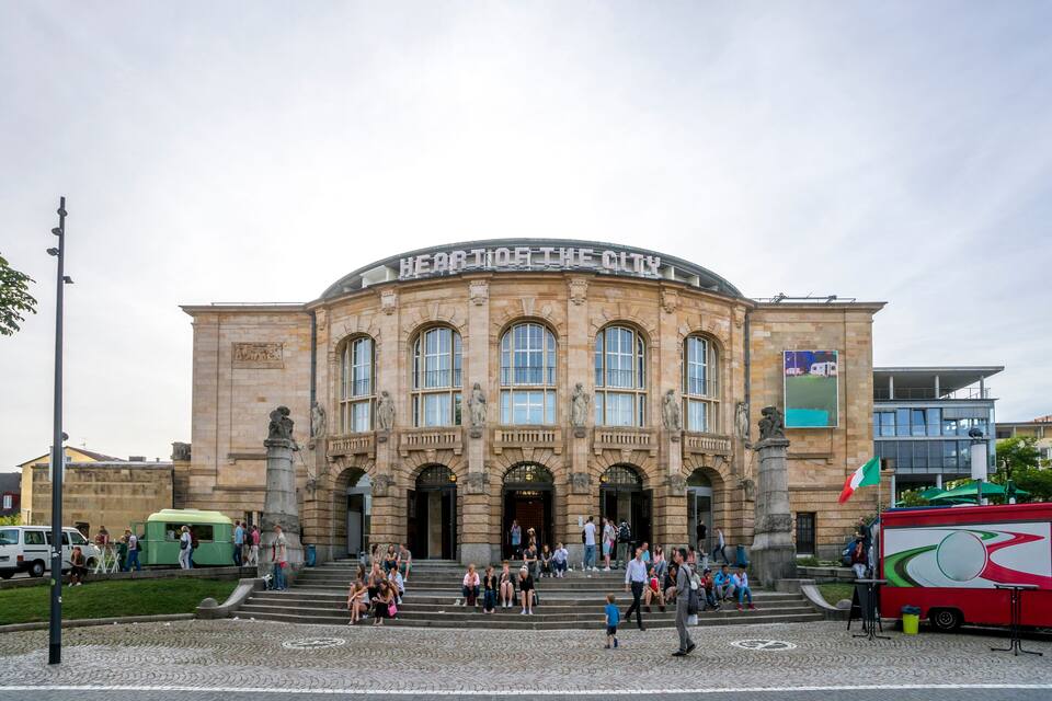 A historic building with the inscription "Heart of the City" and a flag.