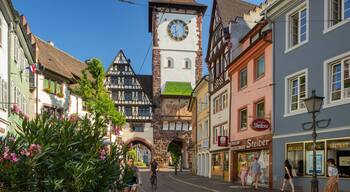 Une place historique, ornée d’un imposant beffroi, de bâtiments traditionnels à colombages et d’une rue pavée.