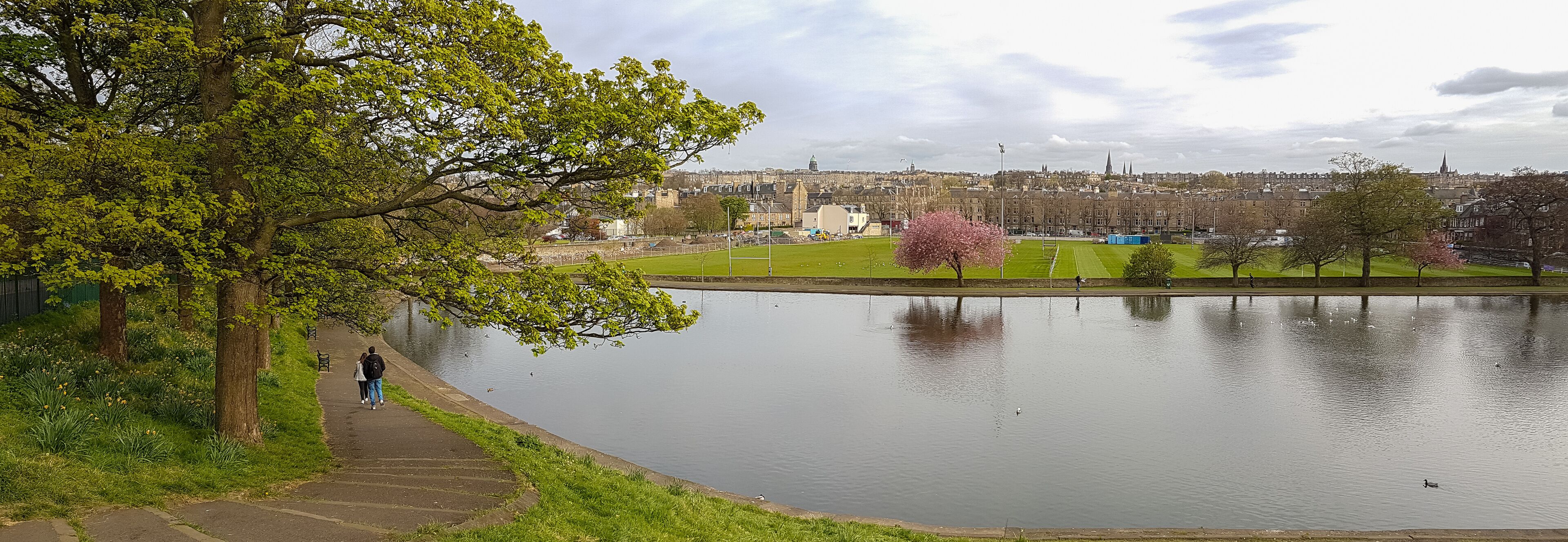 Panoramic romantic view, walking couple at Inverleith Park, Edinburgh, Scotland
