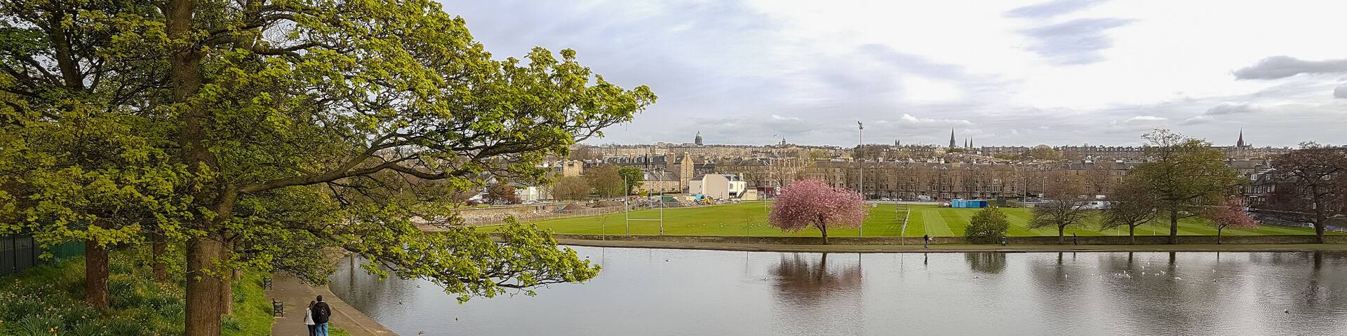 Panoramic romantic view, walking couple at Inverleith Park, Edinburgh, Scotland