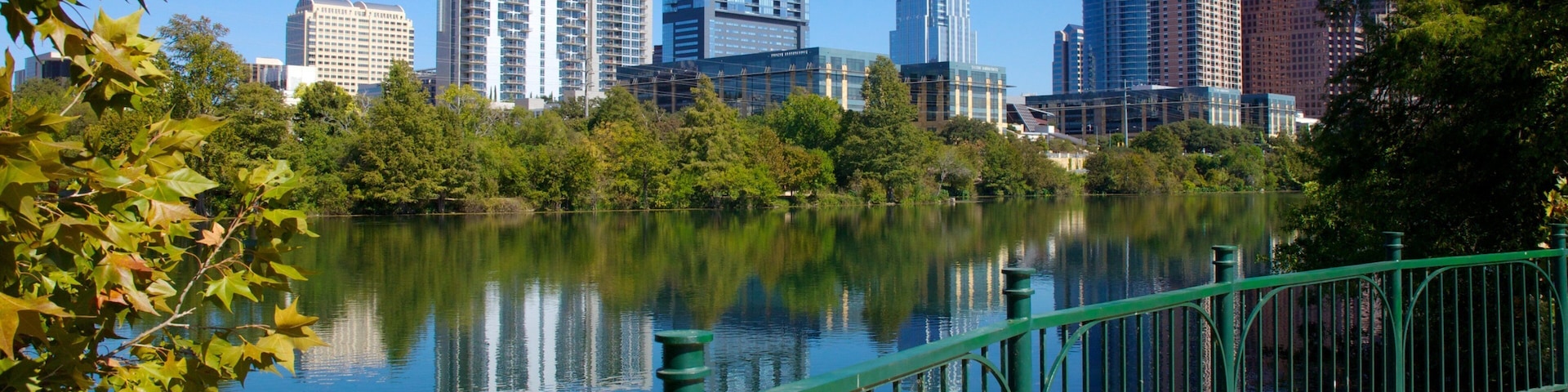 Lakefront view of downtown Austin with skyscrapers reflecting in Lady Bird Lake on a clear day