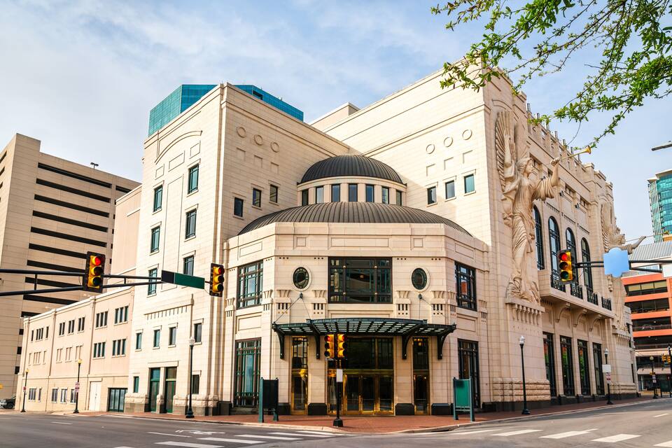 A historic building with a dome, ornate columns, and a statue of a winged figure.
