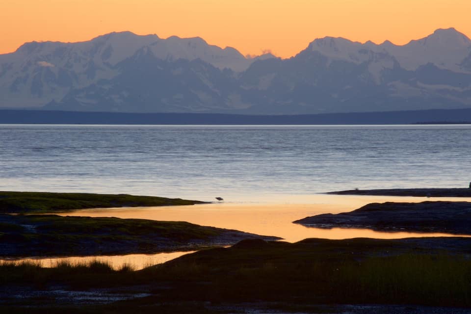Un lac paisible, avec des montagnes en arrière-plan.