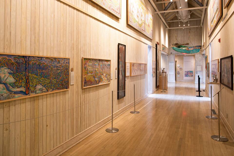 Una galería de arte con paredes de paneles de madera y suelo de madera.