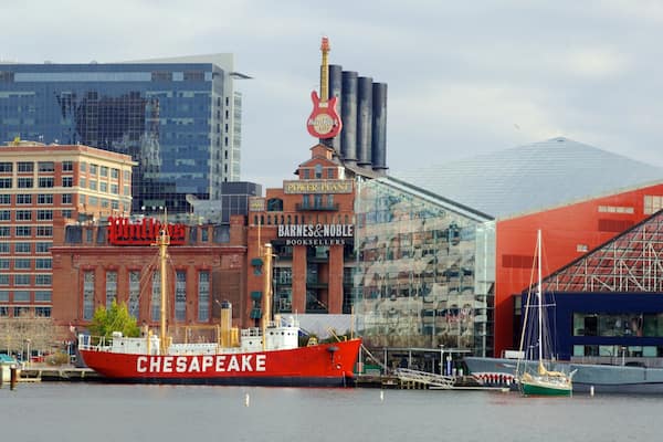 Un navire rouge, baptisé Chesapeake, accosta dans un port, avec une vue sur la ville en arrière-plan.