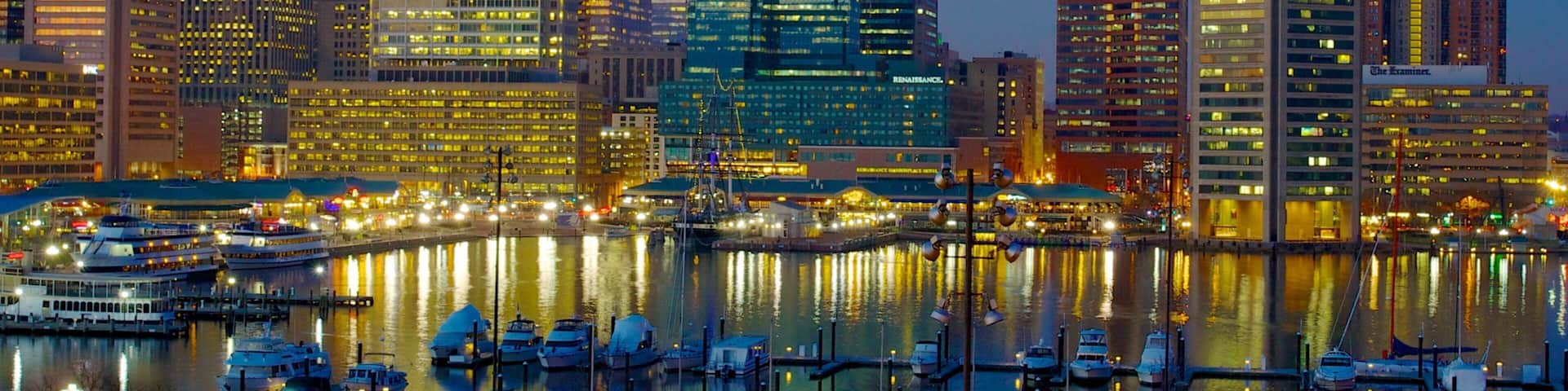 Vibrant evening view of Baltimore Inner Harbor Marina showcasing city skyline and lights