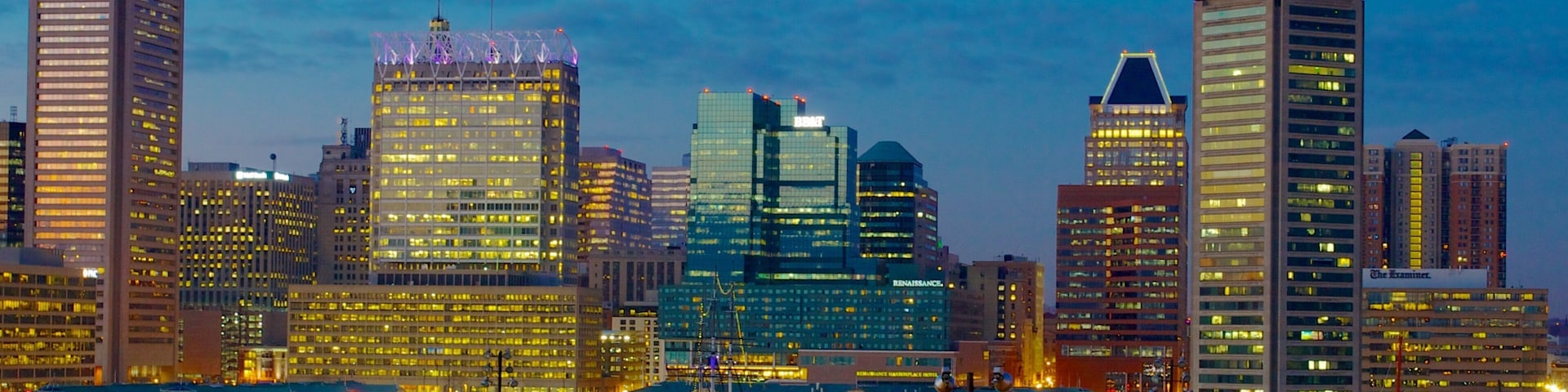 Vibrant evening view of Baltimore Inner Harbor Marina showcasing city skyline and lights