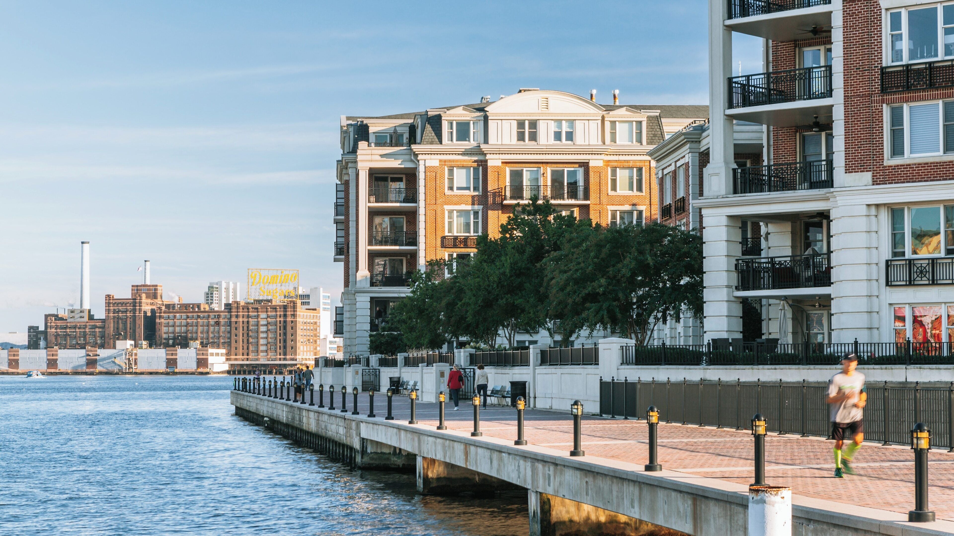 Baltimore Inner Harbor Marina features residential buildings and jogging paths along the water on a sunny day in downtown Baltimore, Maryland