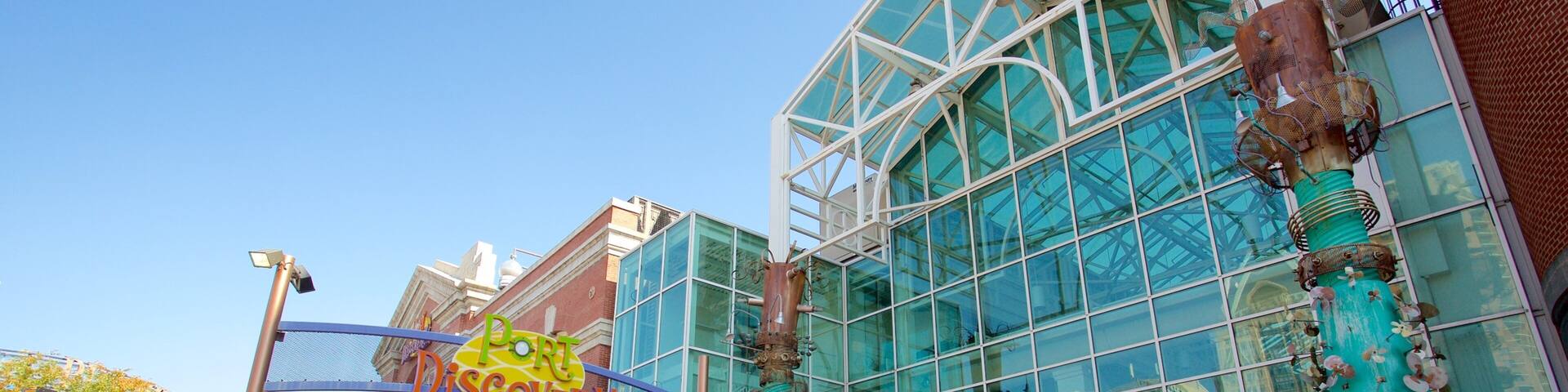 A modern building with large glass windows and a unique sculpture in front.