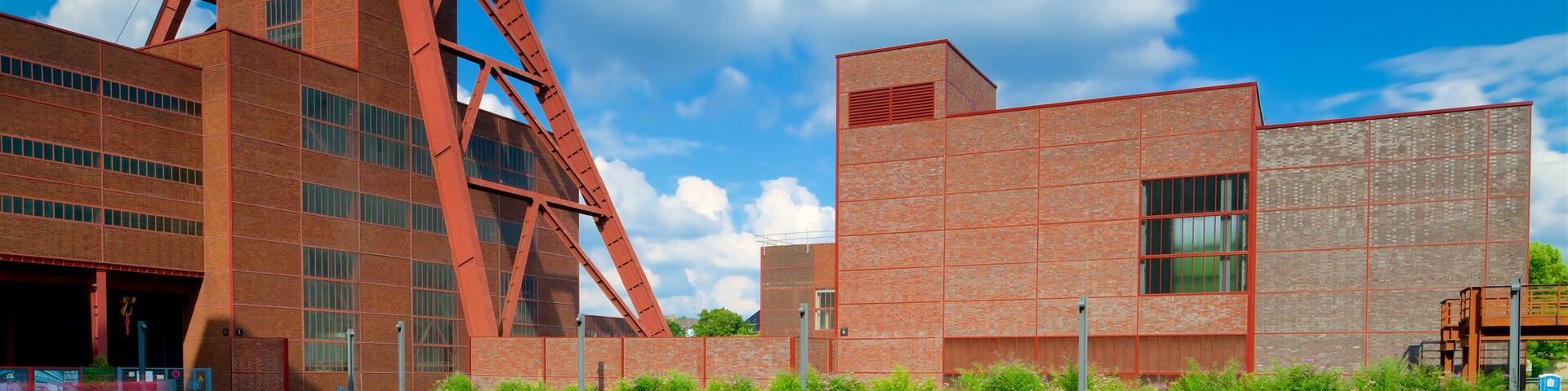 A large red industrial building with a tall tower and a smaller brick building.