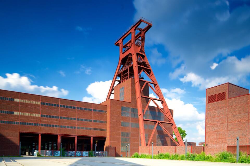 Een groot industrieel gebouw met een opvallende rode torenconstructie.