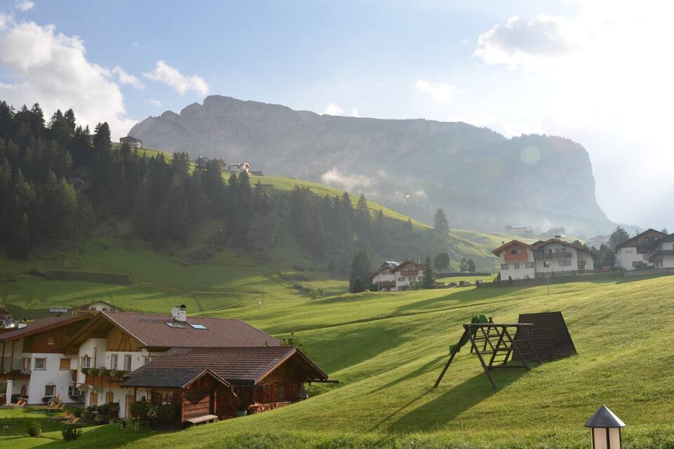 Un pueblo rural con casas, una gran montaña y un cielo despejado.