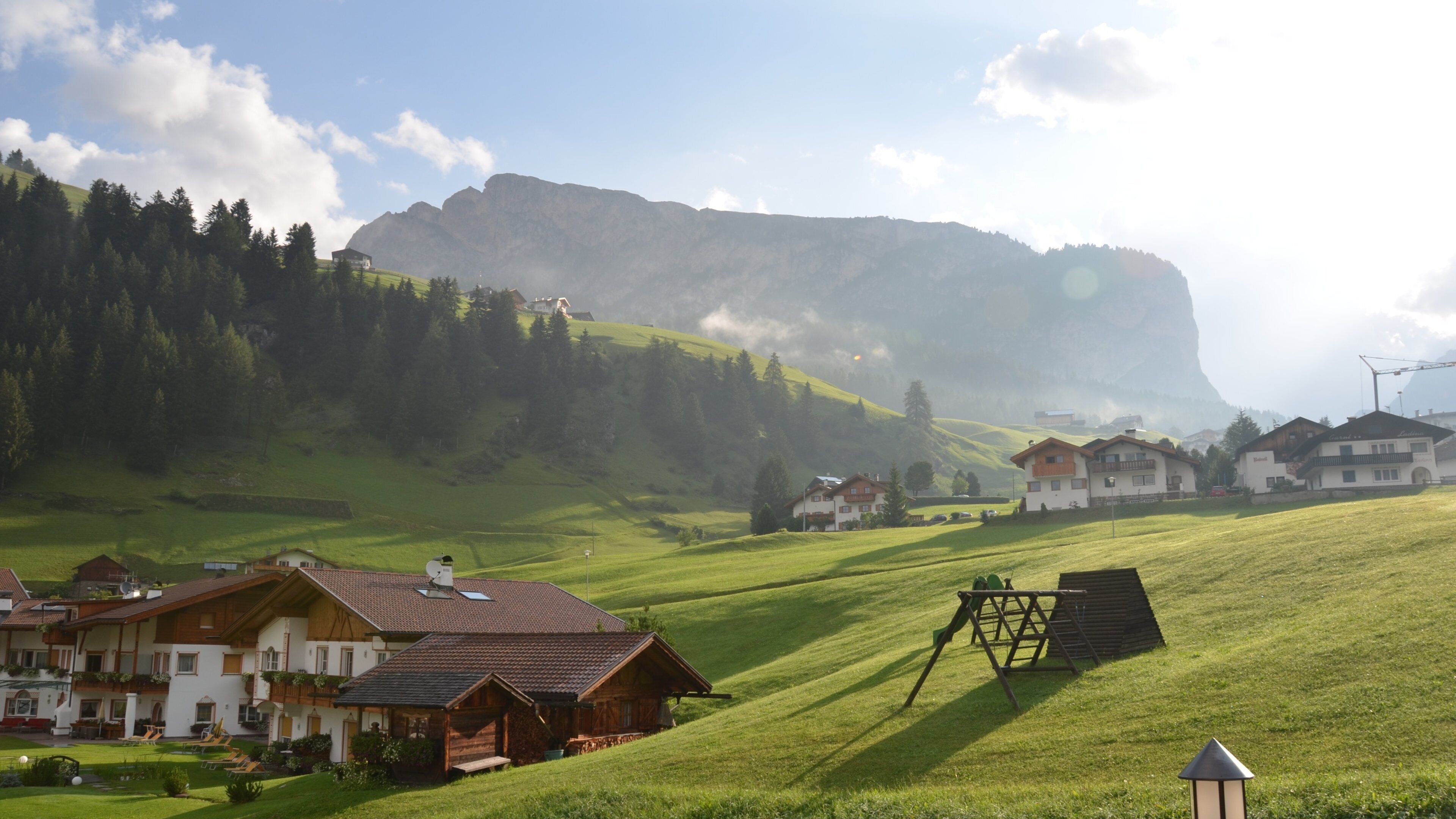 A rural village with houses, a large mountain, and a clear sky.
