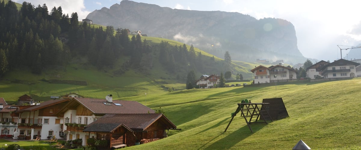 A rural village with houses, a large mountain, and a clear sky.