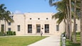 A building with a large entrance and palm trees.