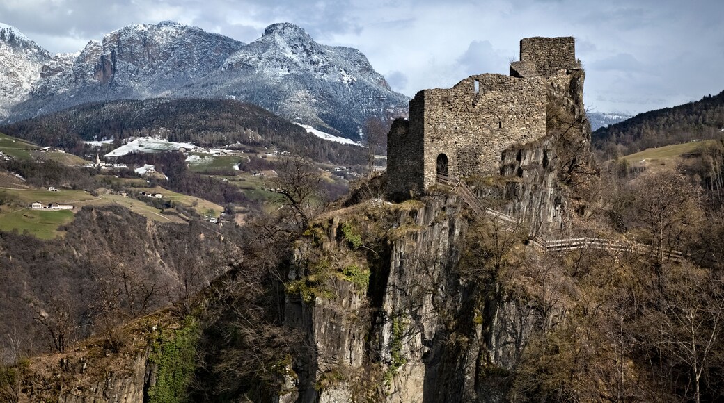 Collepietra: the medieval ruins of Steinegg castle and in the background the Catinaccio dolomite range. South Tyrol, Italy.