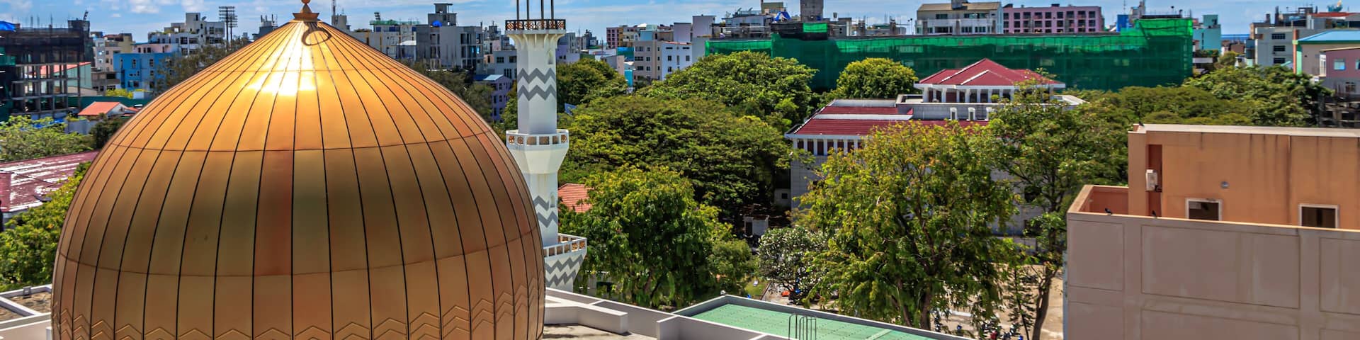 Grand Friday Mosque surrounded by buildings and trees under the sunlight in Male, Maldives