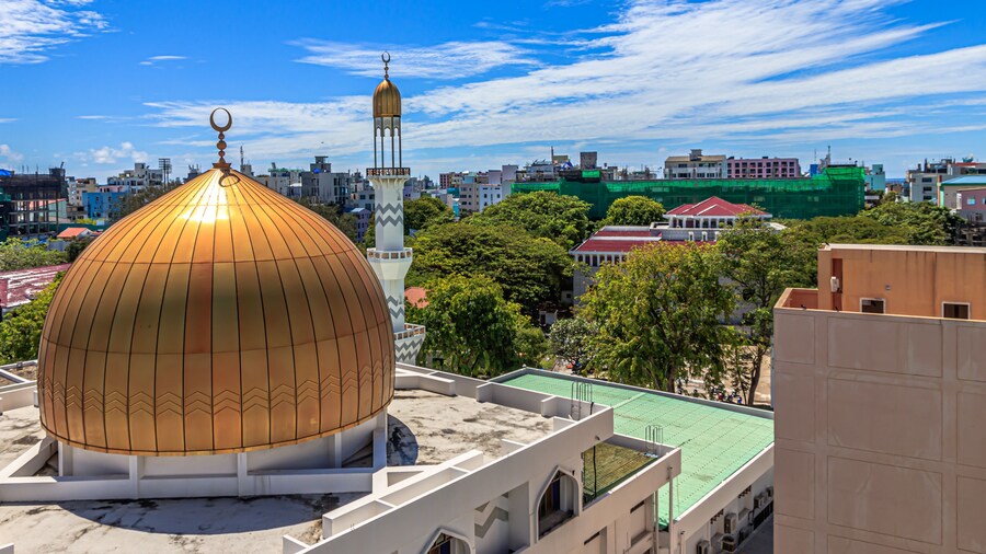 Grand Friday Mosque surrounded by buildings and trees under the sunlight in Male, Maldives