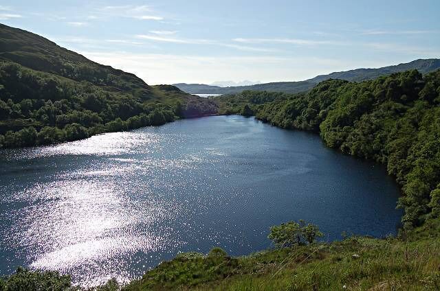 A river winding through a lush valley surrounded by hills.