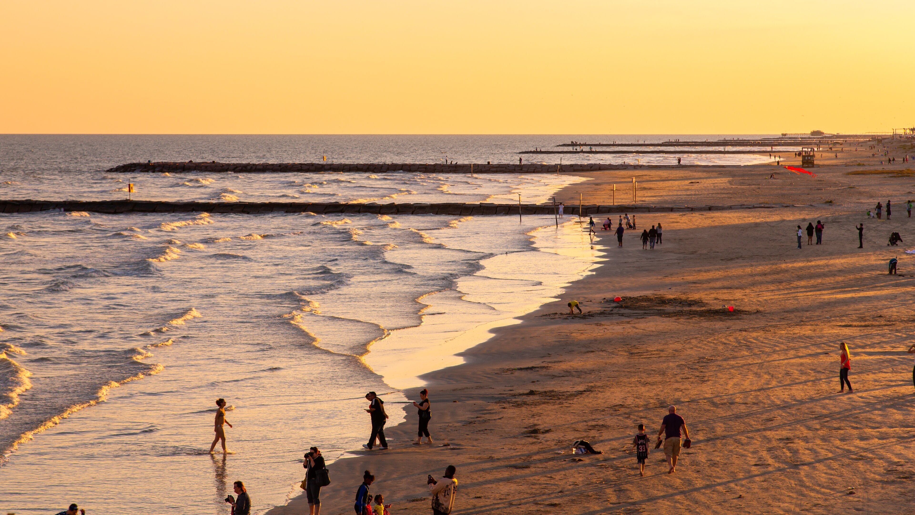 Galveston Island Historic Pleasure Pier showing general coastal views, a beach and a sunset