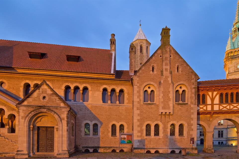 Un edificio histórico con una torre de reloj e iglesia con techo puntiagudo.