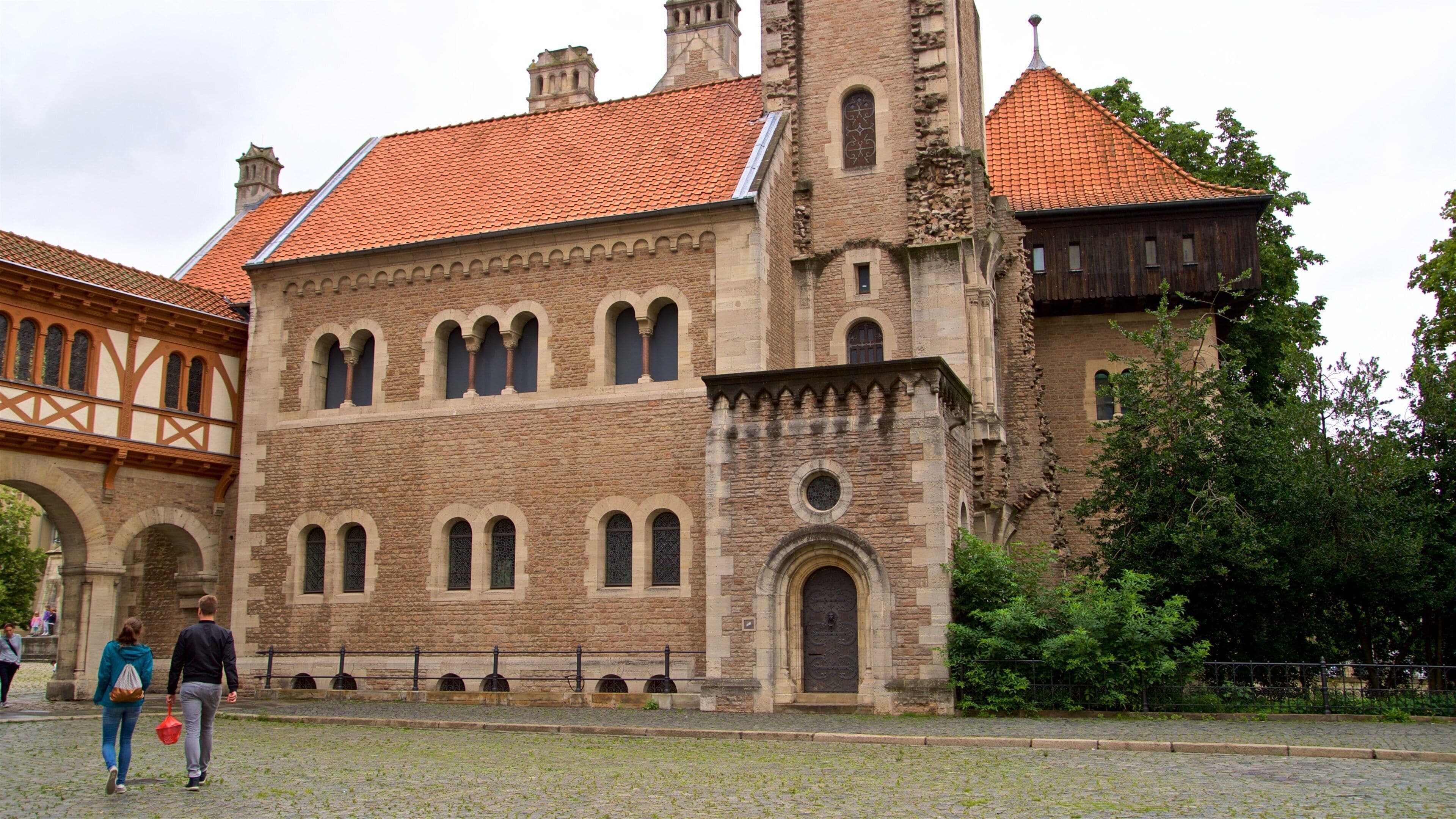 A historic building with a red-tiled roof, arched windows, and a stone facade.