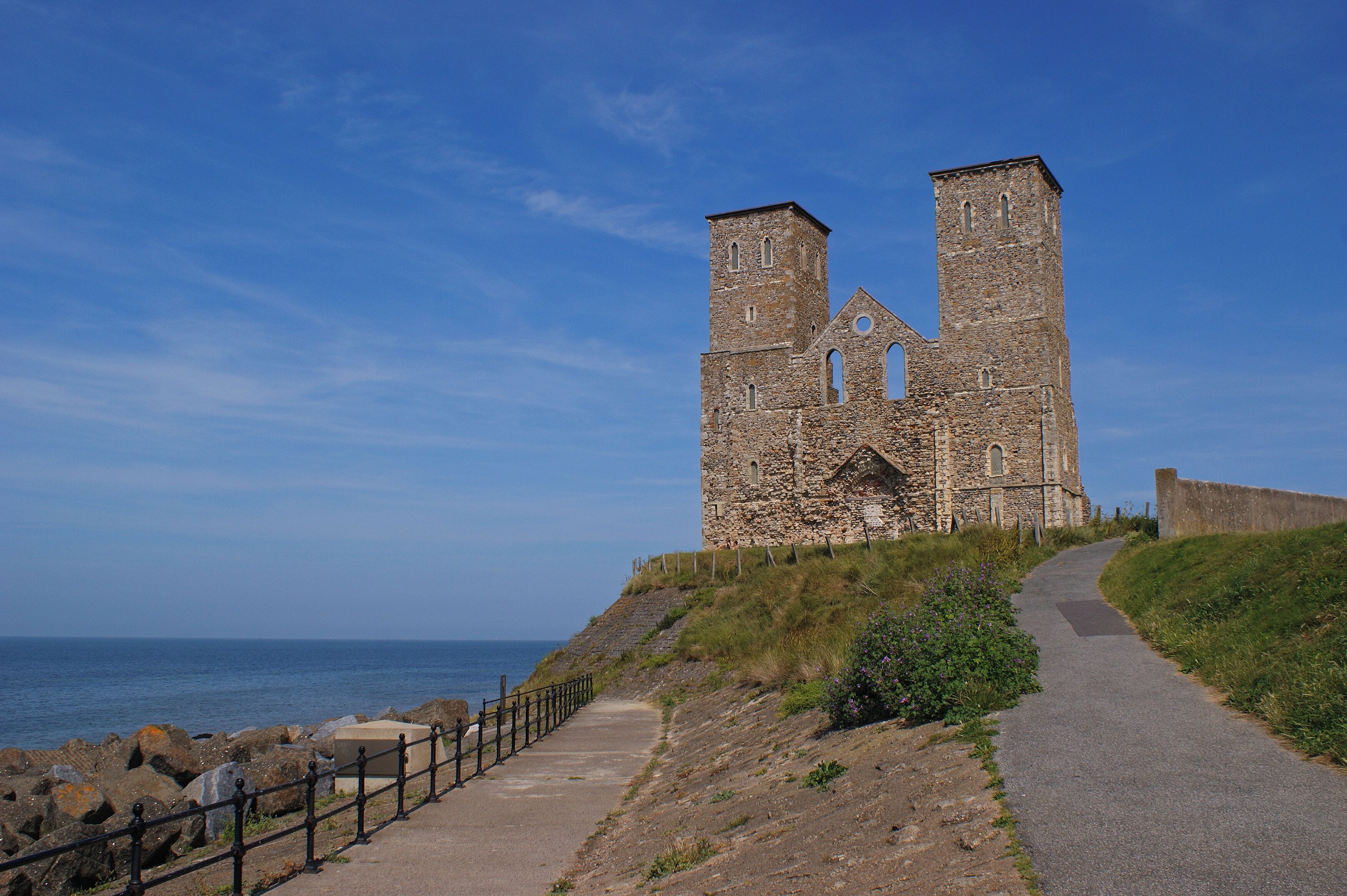 A stone church with two towers by the sea.