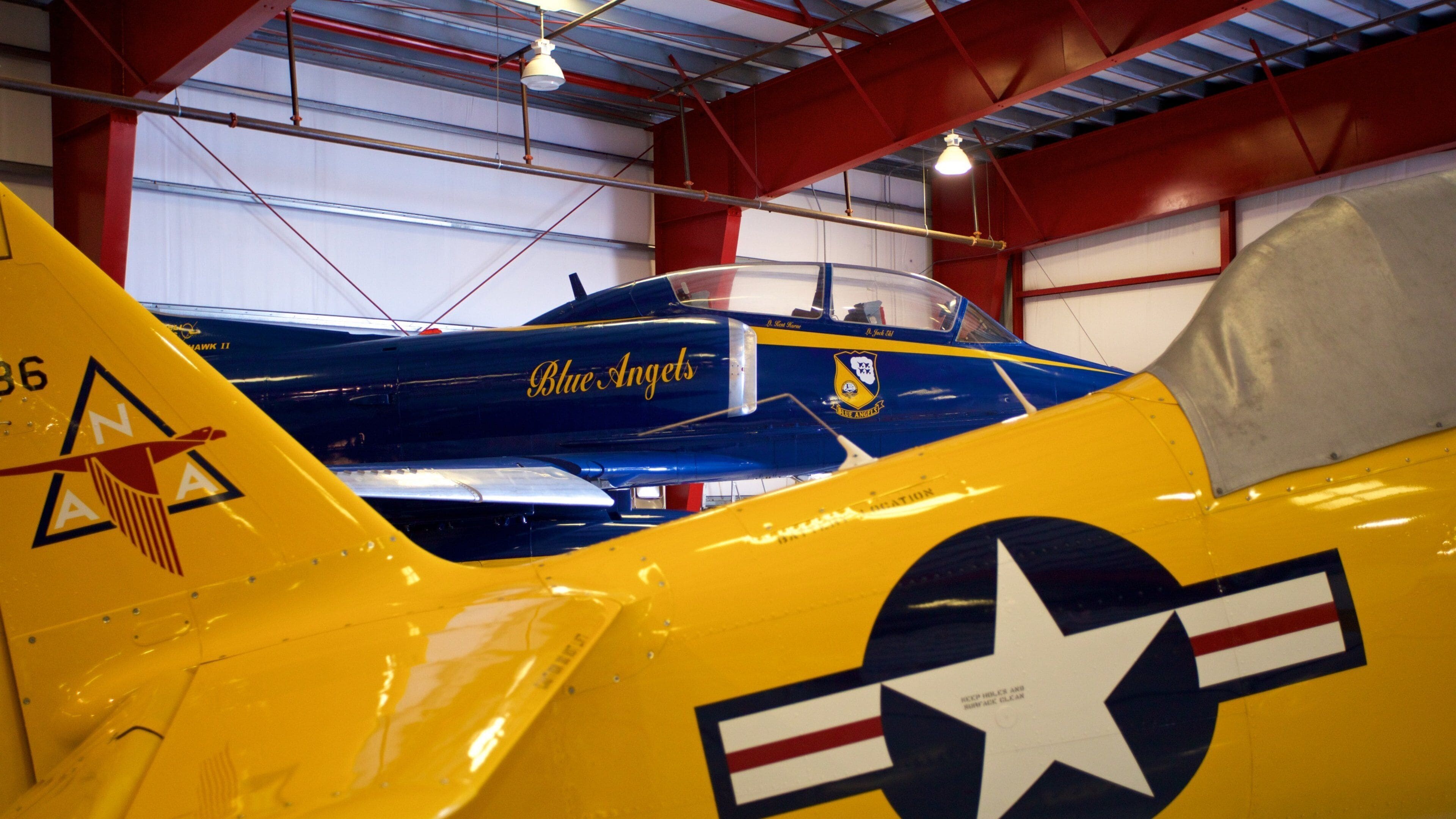A yellow and blue vintage aircraft with the text "Blue Angels" and a star emblem.