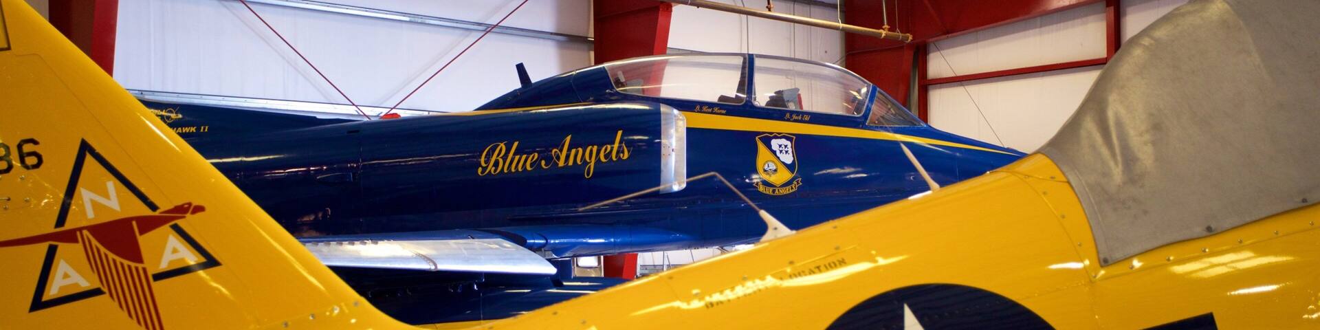 Un avión antiguo amarillo y azul con el texto
