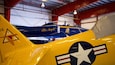 A yellow and blue vintage aircraft with the text "Blue Angels" and a star emblem.