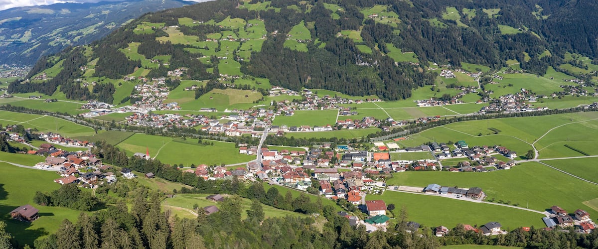 A village nestled in a valley surrounded by mountains.
