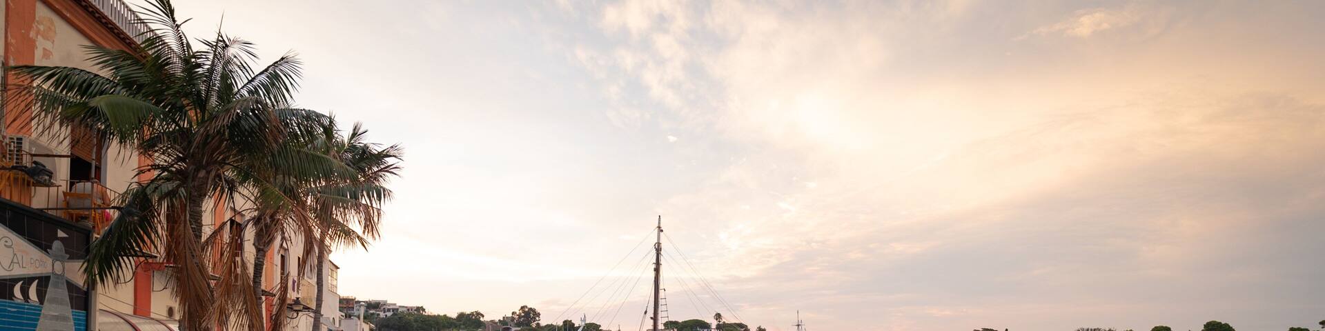 Ischia Port featuring a sunset and a bay or harbor