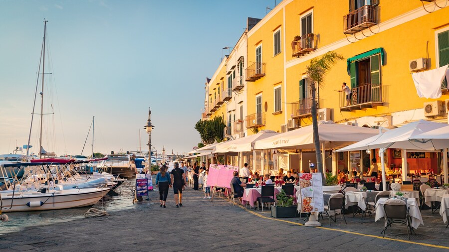 Ischia Port showing a bay or harbor, outdoor eating and a sunset