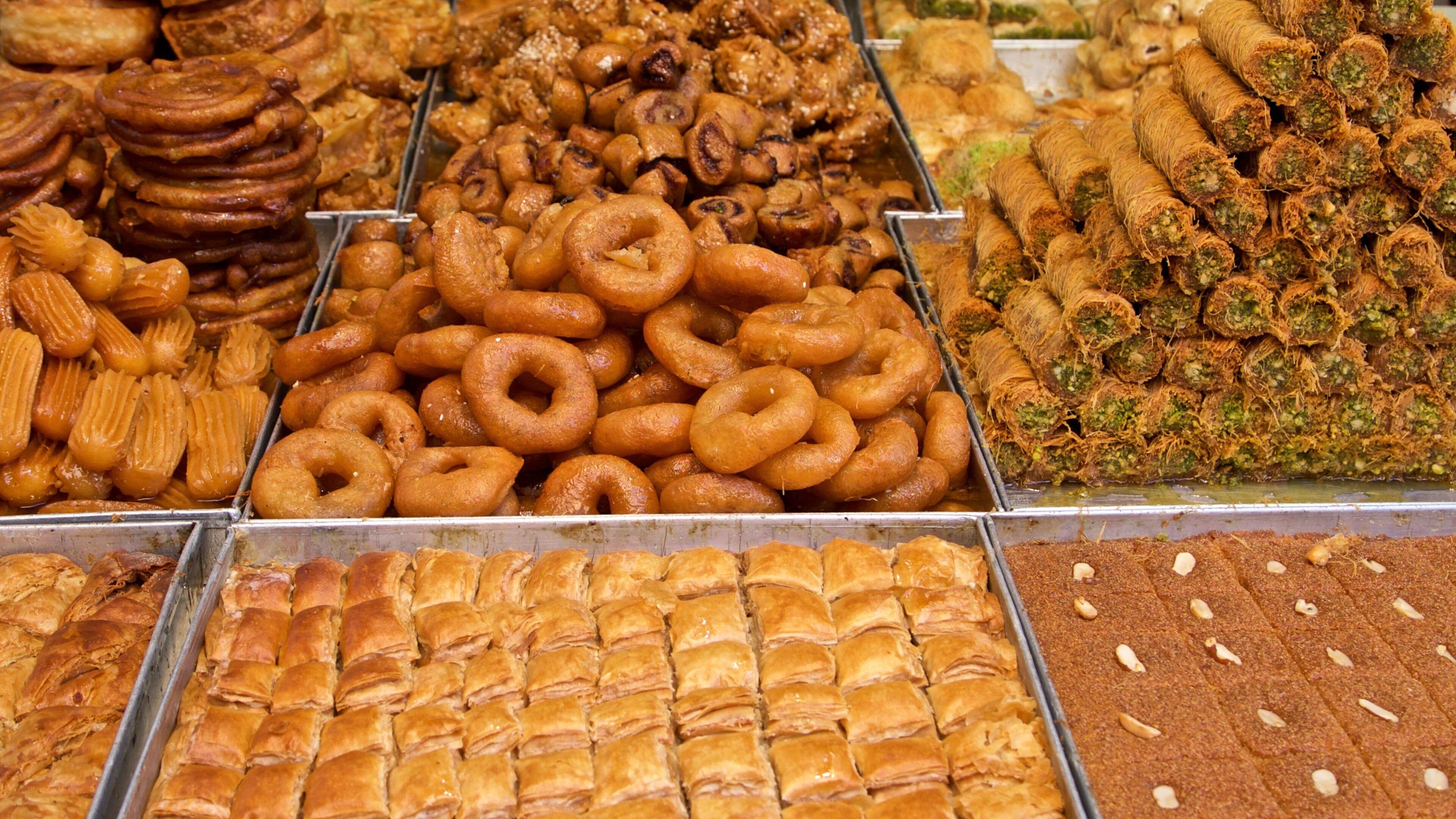 A variety of baked goods including pastries, donuts, and cookies displayed in trays.