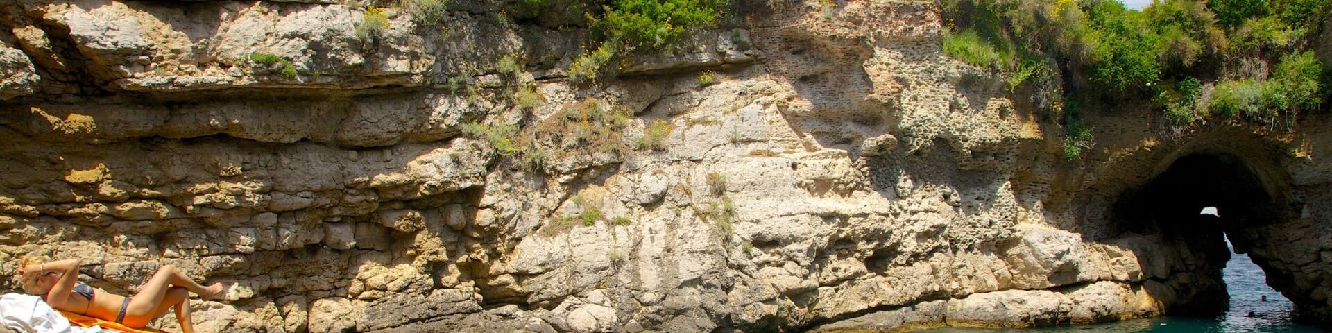 Baths of Queen Giovanna showing rugged coastline as well as a small group of people