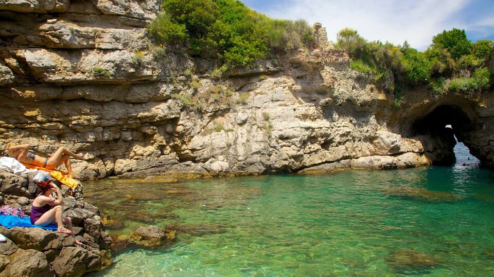 Baths Of Queen Giovanna which includes rocky coastline as well as a small group of people