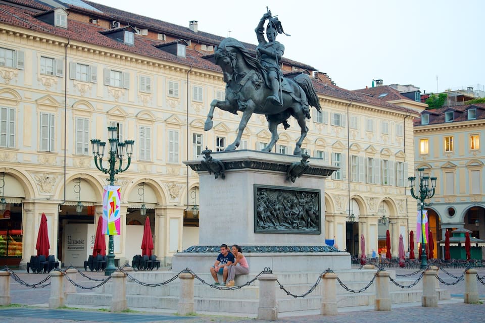A statue of a man on horseback in a square with historic buildings in the background.