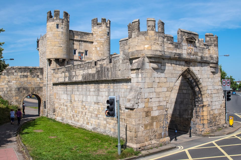 A historic stone castle with a large archway and towers.