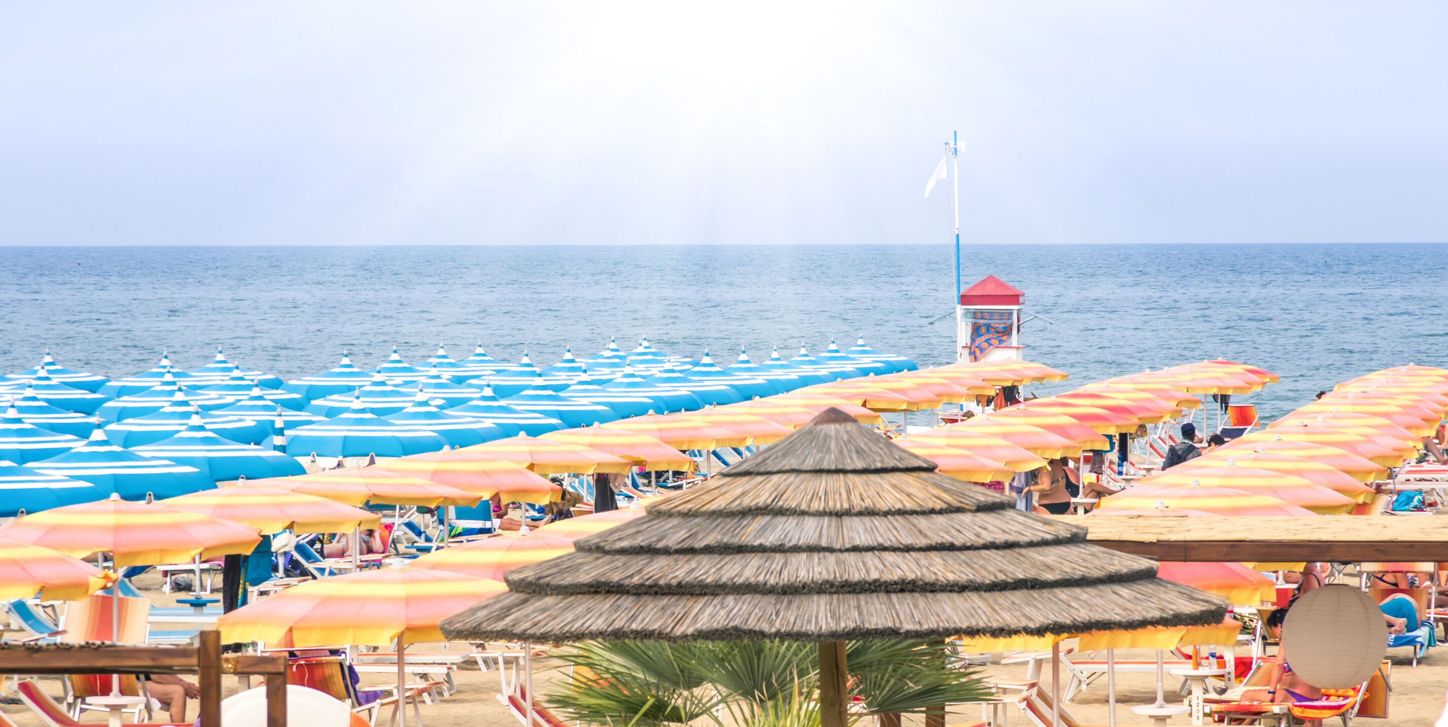 A beach with numerous umbrellas and sun loungers.