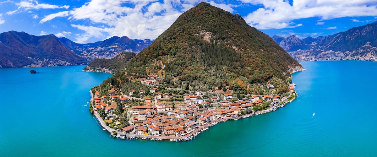 A mountainous island with a dense cluster of buildings and a marina.